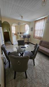 a living room with a couch and a table and chairs at Hidden Bungalow in Roseau +9 photos