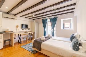 a bedroom with a bed and a desk and a table at Alma do Bairro in Lisbon