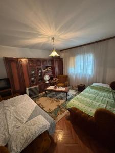 a bedroom with two beds and a table in it at Vila Vuković in Leskovac