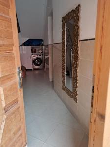 a bathroom with a mirror and a washing machine at Centre boukidan in Al Hoceïma