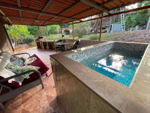 a swimming pool in a house with a table and chairs at Cerroazulfarmlodge in Cerro Azul