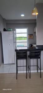 a kitchen with a table and two chairs and a refrigerator at Townhouse Flat Térreo in Ananindeua