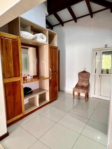 a room with wooden cabinets and a chair and a window at Villa Chez Batista in Takamaka