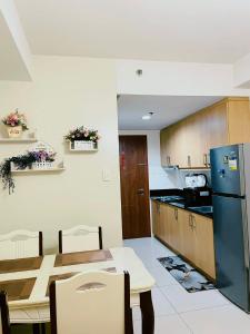 a kitchen with a table and a blue refrigerator at Shell Residences MOA - Josh staycation in Manila