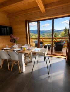a dining room with a table and chairs and a balcony at Domki na Szlaku in Brenna