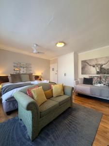 a living room with a bed and a couch at Dolphin Circle Bed and Breakfast in Plettenberg Bay