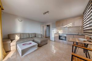 a living room with a couch and a table at ZIS LUX Apartments Pool in Utjeha