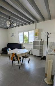 a living room with a table and a couch at La petite maison de Sandra in Le Plessis-Grohan