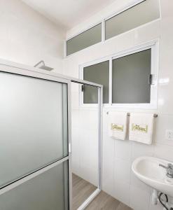 a white bathroom with a shower and a sink at Hotel Museo Carnaval in Huejotzingo +47 photos