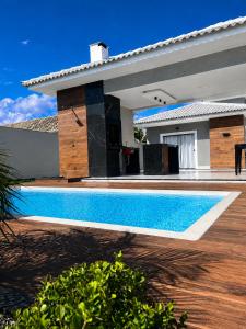 a swimming pool in front of a house at Beach Loft - Design e Estilo in Maricá