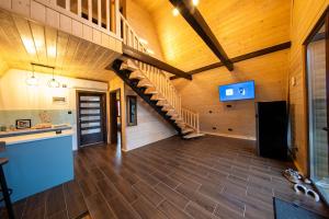 a large room with a wooden ceiling and a staircase at DB Forest Resort in Bucsin
