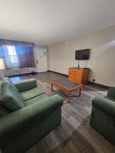 a living room with two couches and a tv at Ramada by Wyndham Westminster Denver in Westminster