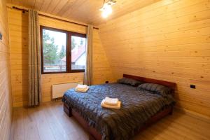 a bedroom with a bed in a wooden cabin at DB Forest Resort in Bucsin