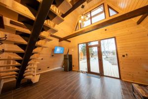 a large room with wooden walls and a wooden staircase at DB Forest Resort in Bucsin