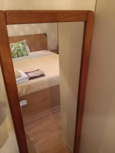a small closet with a mirror next to a bed at Oeiras Central, near Beach & Public Transport in Oeiras +5 photos