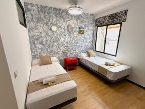 a bedroom with two beds and a window at Evans Realty - Hostal in Fuengirola +35 photos