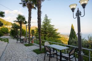 a patio with tables and chairs and palm trees at Hotel Palasa in Palasë +58 photos