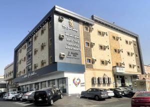 a building with cars parked in a parking lot at بست تريب ميلانو للشقق المخدومة in Jeddah
