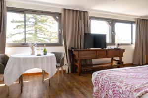 a hotel room with a table and a bed and a desk at Ermitage De Corton - Teritoria in Chorey-lès-Beaune