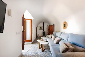 a living room with a blue couch and a table at Molino Son Moll in Cala Ratjada