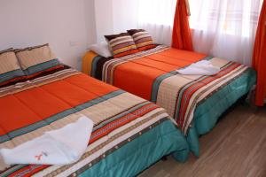 two beds sitting next to each other in a room at Hotel Inkanta in Ipiales