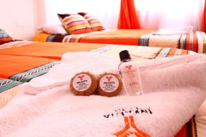 two beds with towels and bottles on top of them at Hotel Inkanta in Ipiales +1 photo