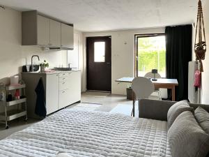 a bedroom with a bed and a kitchen and a table at Sommarboende i centrala Varberg in Varberg +2 photos