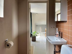 a bathroom with a sink and a toilet and a table at Sommarboende i centrala Varberg in Varberg