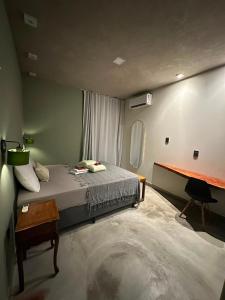 a bedroom with a bed and a desk in it at Casa Super Paradise in Rio Tinto
