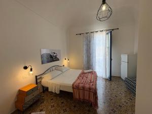 a bedroom with a bed and a large window at Struttura Le Gemme in Marettimo +5 photos