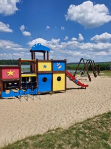 a playground on the beach with a swing at Apartament BLASK Jeziora in Augustów