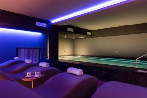 a room with a swimming pool with purple lighting at Hotel Orso Grigio in Selva di Cadore