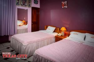 two beds in a hotel room with purple walls at Hospedaje Texas city in La Merced