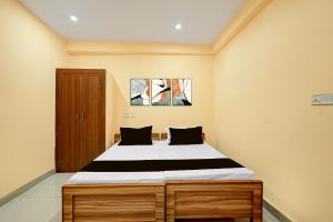a bedroom with a large bed with black and white sheets at Spot ON Hotel Gyanvi Palace in Bhopal