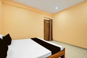 a bedroom with a bed and a door to a window at Spot ON Hotel Gyanvi Palace in Bhopal