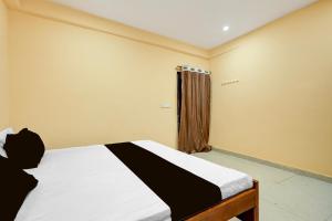 a bedroom with a bed and a window at Spot ON Hotel Gyanvi Palace in Bhopal