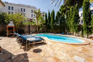 a pool with chairs and a table next to a building at Molino Son Moll in Cala Ratjada