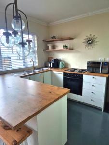 a kitchen with a sink and a stove top oven at Fortune Cottage in Cape Town