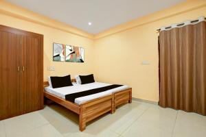 a bedroom with a bed and a brown curtain at Spot ON Hotel Gyanvi Palace in Bhopal