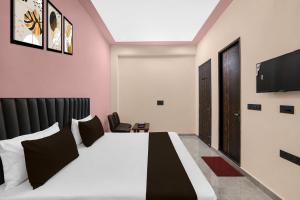 a hotel room with a bed and a flat screen tv at Hotel O Global Residency in Gurgaon