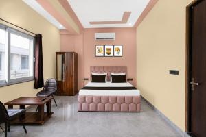 a bedroom with a bed and a chair and a table at Hotel O Global Residency in Gurgaon +24 photos