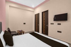 a bedroom with a bed and a tv on the wall at Hotel O Global Residency in Gurgaon
