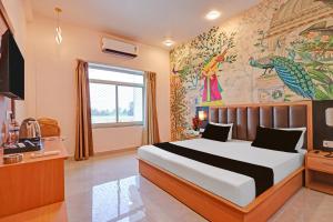 a bedroom with a bed and a painting on the wall at Hotel O Gomti Garden And Resort in Jhānsi