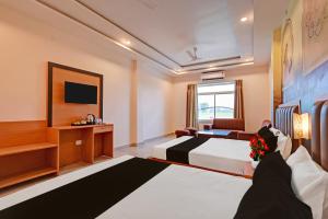 a hotel room with a bed and a tv at Hotel O Gomti Garden And Resort in Jhānsi