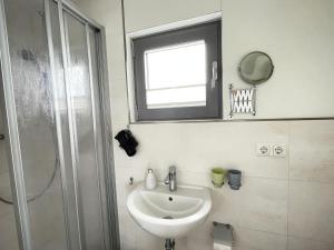 a bathroom with a sink and a window and a shower at Hausboot Paula mit Reisekajak in Ribnitz-Damgarten in Ribnitz-Damgarten
