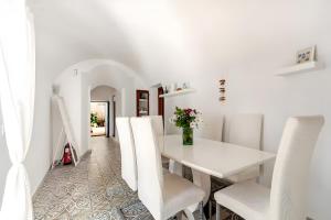 a white dining room with a white table and chairs at Molino Son Moll in Cala Ratjada