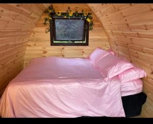 a bed in a wooden room with a window at Buttys place in Abergavenny
