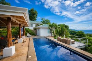 a swimming pool in a villa with a view of the ocean at Lodge Las Estrellas de Samara - Ocean View in Sámara