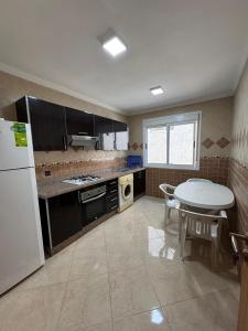 a kitchen with a table and a white refrigerator at Saramica Apartamento in Riffiene