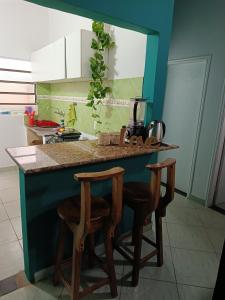 a kitchen with a counter and two stools at a kitchen island at Turquesa in Hernandarias